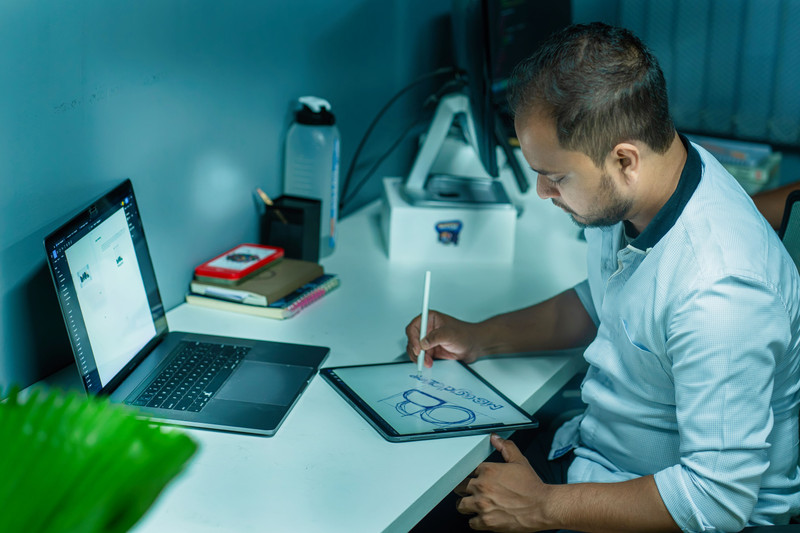 A designer drawing on a tablet at his desk.
